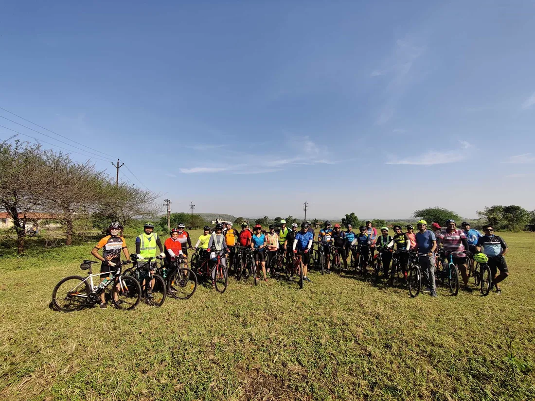 A big group of riders with their bikes in a field